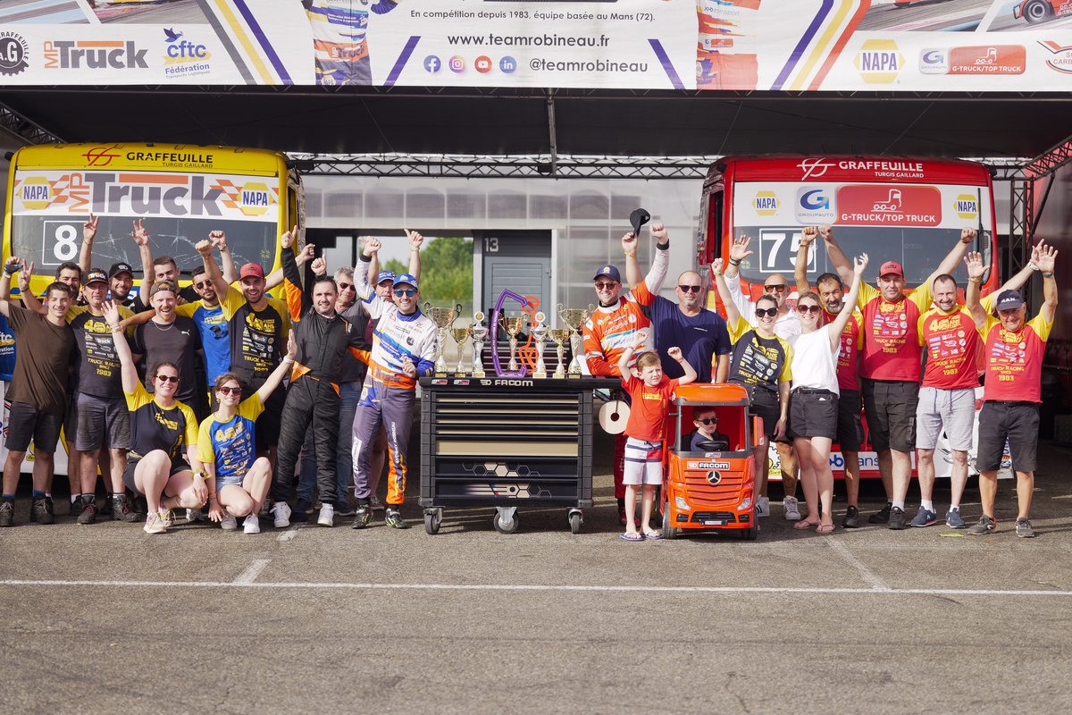 Toute l’équipe Team Robineau célèbre la victoire devant les camions #8 et #75 et les trophées de Nogaro